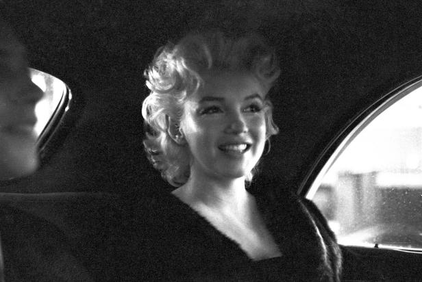 NEW YORK - MARCH 30: Actress Marilyn Monroe rides in the back of a car with Dick Shepherd on March 30, 1955 in New York City, New York. (Photo by Ed Feingersh/Michael Ochs Archives/Getty Images)  
