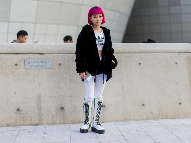SEOUL, SOUTH KOREA - OCTOBER 18: A guest with pink hair wearing an Adidas shirt, Dr. Martens boots, white pants and black jacket on October 18, 2016 in Seoul, South Korea. (Photo by Christian Vierig/Getty Images)