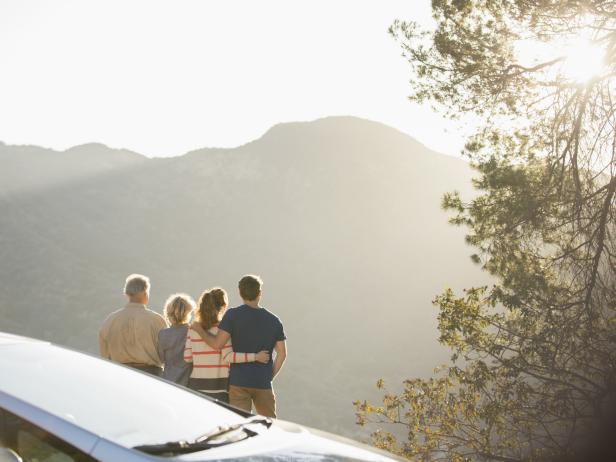 Family looking at mountain view outside car