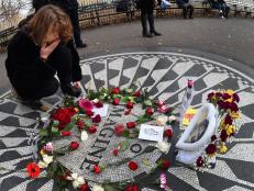 Emma Bassant from Toronto, Canada places flowers at the mosaic named for the John Lennon's song "Imagine" December 8, 2015 at Strawberry Fields, the Central Park garden dedicated in his honor, in New York. Today marks the 35th anniversary of the night John Lennon was gunned down by Mark David Chapman outside his home in New York City.    AFP PHOTO / TIMOTHY A. CLARY / AFP / TIMOTHY A. CLARY        (Photo credit should read TIMOTHY A. CLARY/AFP/Getty Images)