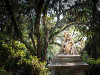 "Tombstones, sculpture  and gravesite at Bonaventure Cemetery, Savannah, Georgia. Live Oak trees and Spanish Moss in the background. Shallow DOF."