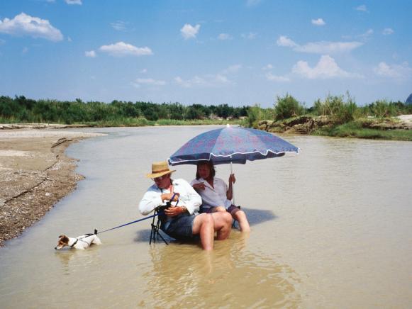 People relaxing by sitting in Rio Grande.