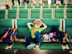 Young boy waiting at airport boarding hour.