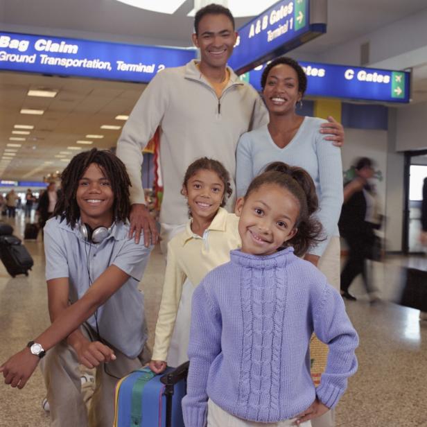 Family standing at baggage claim in airport, portrait