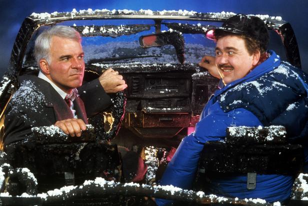 Steve Martin and John Candy sit in a destroyed car in a scene from the film 'Planes, Trains & Automobiles', 1987. (Photo by Paramount/Getty Images)