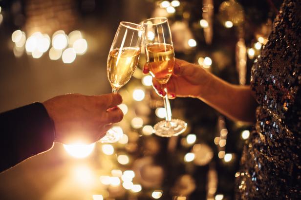 Toasting champagne in front of a Christmas tree.