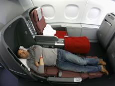 SYDNEY, AUSTRALIA - SEPTEMBER 21:  A man sleeps in the new business class seat onboard the new Qantas A380 flagship the 'Nancy-Bird Walton' as she joins the Qantas fleet at Sydney Domestic Airport on September 21, 2008 in Sydney, Australia. The Qantas A380 will feature seating for 450 passengers across four cabins and will commence commercial services from Melbourne to Los Angeles on October 20, and from Sydney to Los Angeles on October 24.  (Photo by Sergio Dionisio/Getty Images)