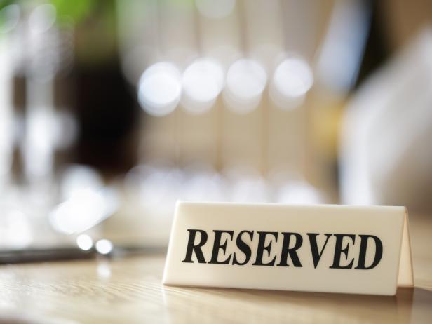Restaurant reserved table sign with places setting and wine glasses