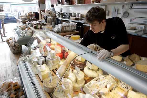 An employee at Beecher's Handmade Cheese arranges the display window at the Pike Place Market in Seattle, Washington on Thursday, March 2, 2006. Photographer: Kevin P. Casey/Bloomberg News