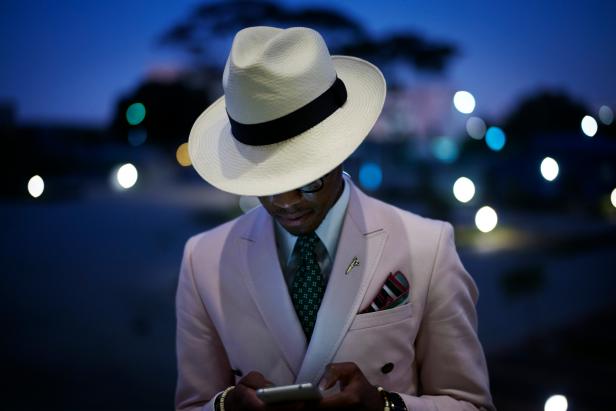 CAPE TOWN, SOUTH AFRICA JULY 2: A fashionable man chats on his phone while waiting for a show at South Africa Menswear week 2015 on July 2, 2015 in Cape Town, South Africa. The second edition of SAMW featured designers from South Africa and around Africa showing spring and summer collections during the 3-day event. (Photo by Per-Anders Pettersson/Getty Images)
