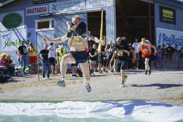 Taisto Miettinen and Kristiina Haapanen of Finland (L) compete during the Wife Carrying World Championships in Sonkajaervi, Finland, on July 1, 2017. / AFP PHOTO / Lehtikuva / Timo Hartikainen / Finland OUT        (Photo credit should read TIMO HARTIKAINEN/AFP/Getty Images)