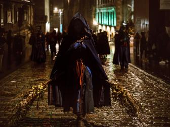 Edinburgh, UK - October 31, 2016: Members of the Beltane Fire Society perform along the Royal Mile in the city centre on a rainy night. Blue painted performers clear the way though the crowds ahead of the main parade. Samhuinn, or Halloween, is the Celtic New Year and celebrated with a procession and performance through the city streets.