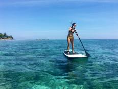 Woman practicing stand up paddle at Beach peaceful paradise at Bali