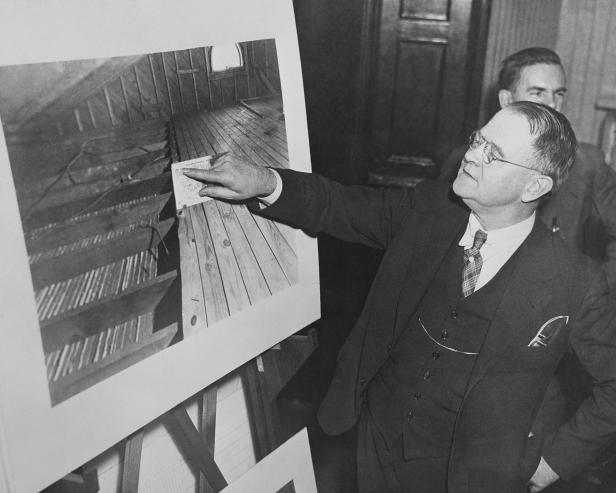 (Original Caption) Frederick Pope, a member of the defense counsel fighting to keep Bruno Richard Hauptmann from going to the chair for the kidnapping and murder of Charles A. Lindbergh, Jr., is pictured in the Hunterdon County Court, Flemington, January 25th, looking at a photostatic copy of the attic of Hauptmann's home. It is the State's contention that the board missing from the part of the floor covered was used in the ladder which the kidnaper used to enter the baby's room.