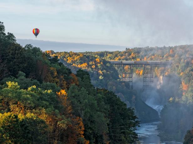 Sunrise From Inspiration Point At Letchworth State Park In New York With A Hot Air Balloon Flying Near The Railroad Trestle