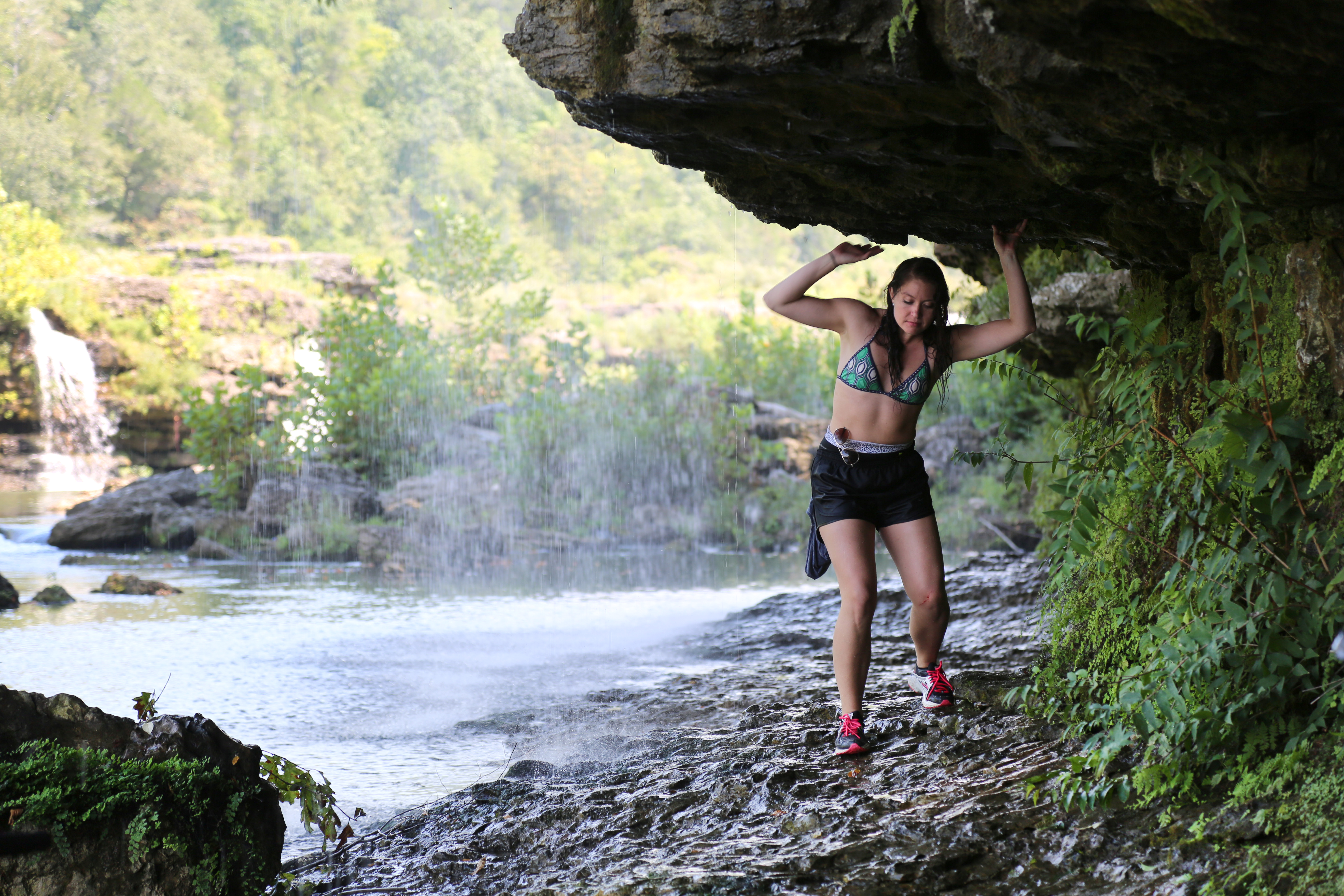 Whitney Stroup walking under rocks near Great Falls in Rock Island, Tennessee as seen on Travel Channel's Top Secret Waterfalls episode TTWF101H.
